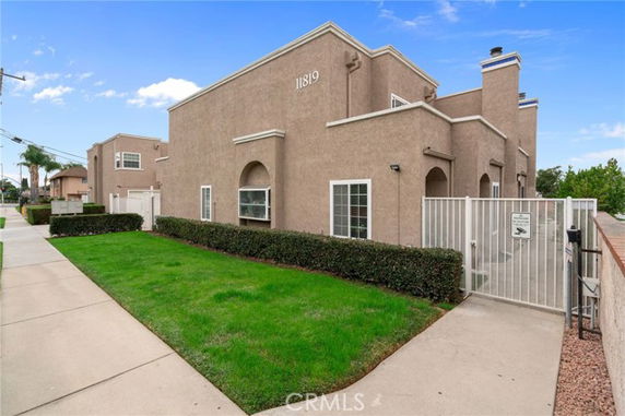Front view of a multi-story building with a gated entrance and arched window design.