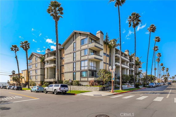 Front view of a multi-story residential building with balconies and large windows.
