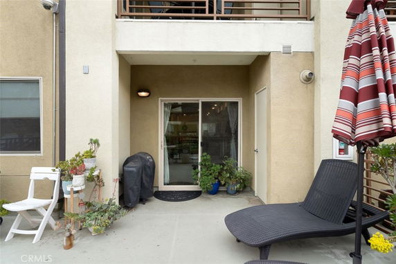 Front view of a house featuring a small patio area with sliding glass doors.