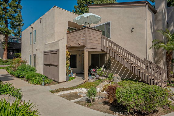 Front view of a two-story residential building with an external staircase.
