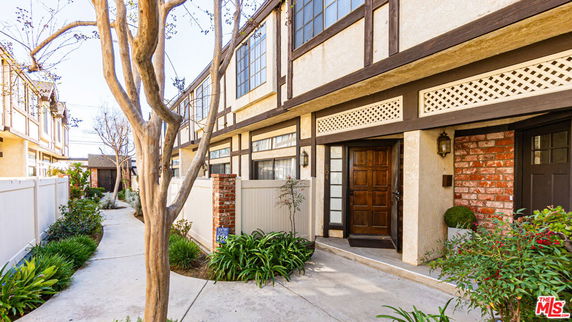 Front view of a multi-story building with wooden accents and a pathway leading to the entrance.