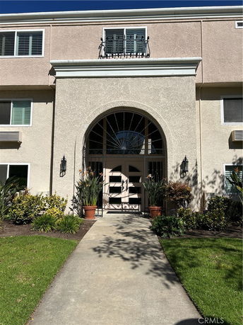 Front view of a multi-story building with an arched entrance.