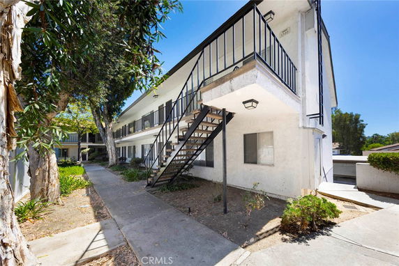 Front view of a two-story apartment building with exterior staircase