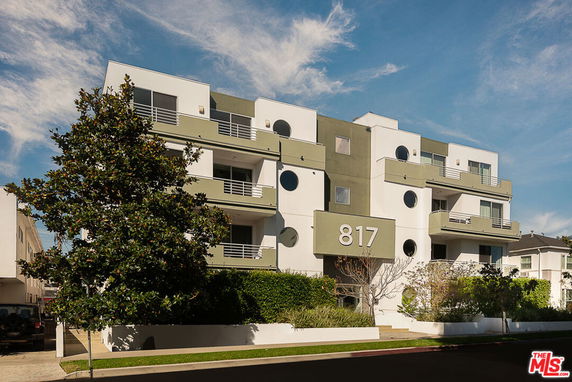Front view of a multi-story building with balconies and the number 817 on the facade.