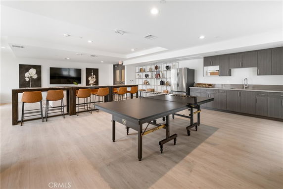 Indoor recreation area with a ping pong table, bar seating, and kitchen facilities.
