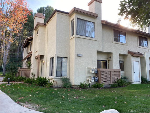 Front view of a two-story townhouse with beige exterior and corner windows.
