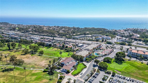 Panoramic aerial view of a coastal area with buildings, roads, and the ocean in the background.