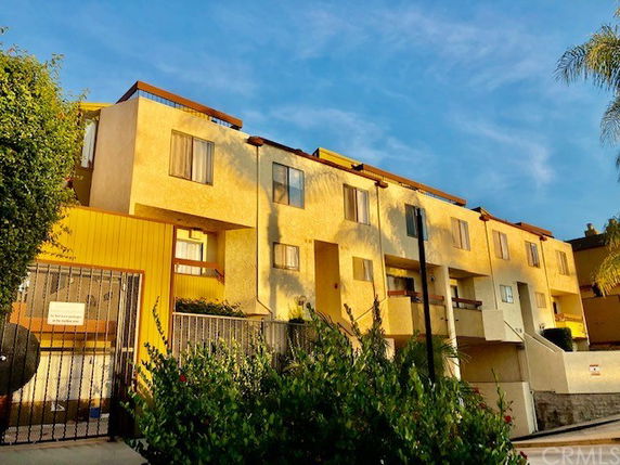 Front view of a multi-story apartment building with balconies.