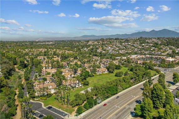 Aerial view of a residential area with multiple buildings surrounded by greenery and roads.