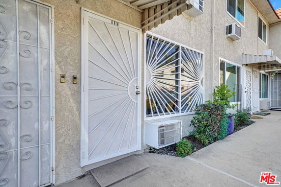 Front view of a house with white security doors and window grilles.