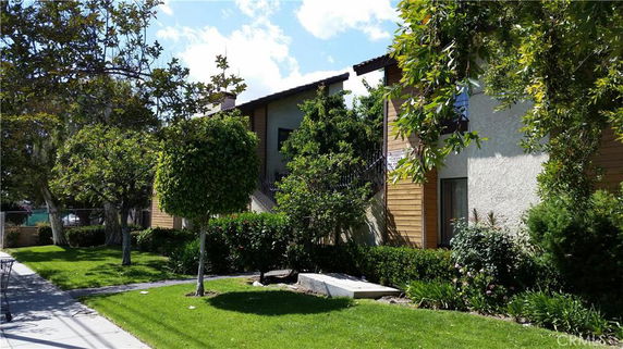 Front view of a residential building with multiple units and wooden paneling.