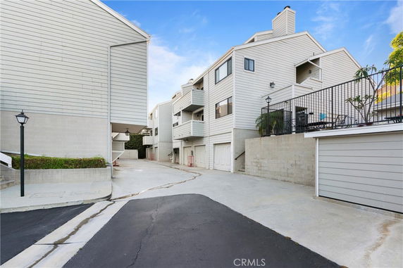 Front view of multi-story residential buildings with garages and balconies.