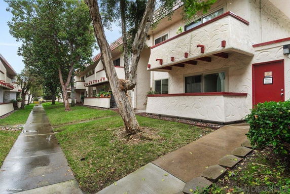 Front view of a two-story residential building with balconies and a walkway.