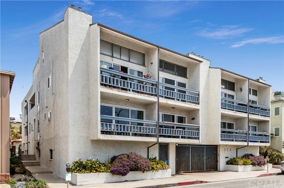 Front view of a multi-story apartment building with balconies.
