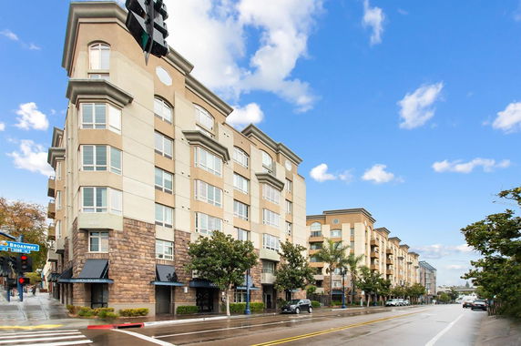Front view of a multi-story apartment building along a city street.