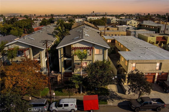 Front view of a multi-story residential building with a sloped roof and open balconies.