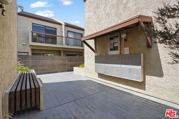 Front view of a residential building with multiple mailboxes and balconies.
