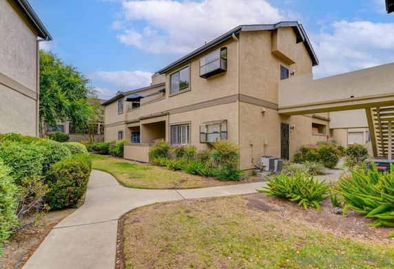 Front view of a two-story residential building with pathways and landscaping.