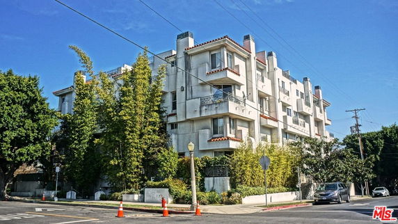 Front view of a multi-story apartment building with balconies.