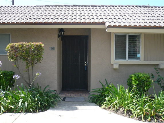 Front view of a single-story house with a tiled roof and black front door.