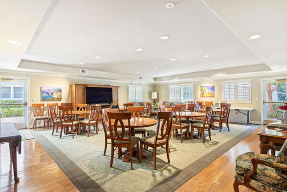 Interior view of a clubhouse with tables and chairs set up for social activities.
