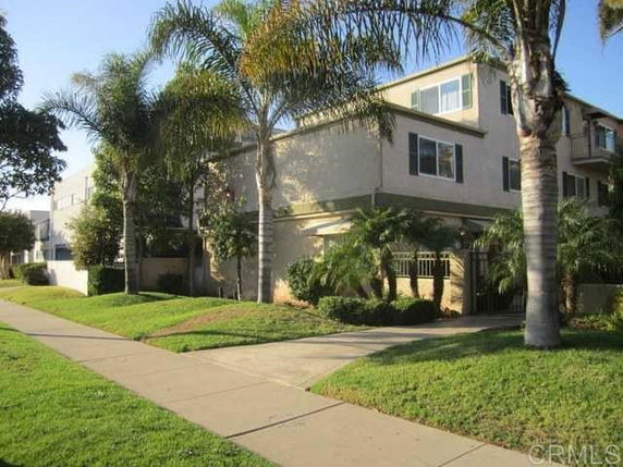Front view of a multi-story house with a surrounding garden.