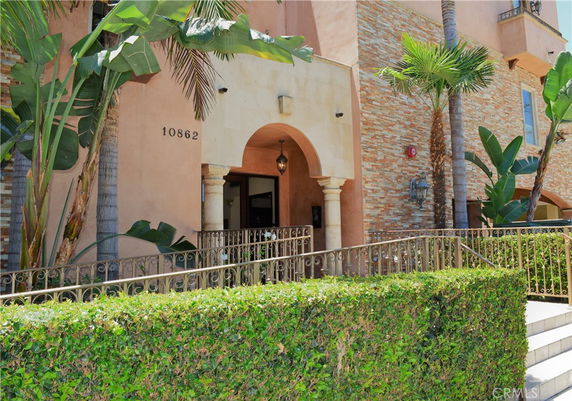 Entrance view of a building with arched doorway and stone facade.
