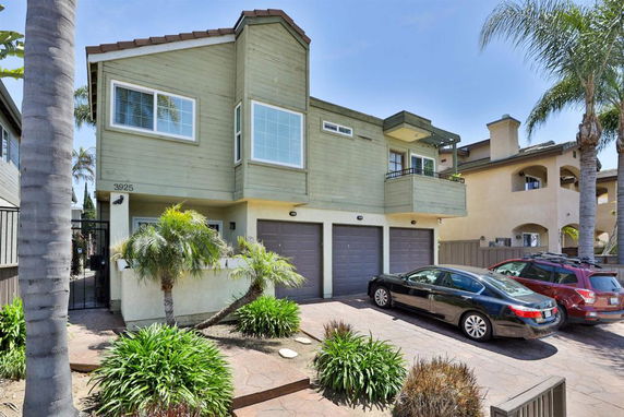 Front view of a two-story house with a balcony and three-car garage.
