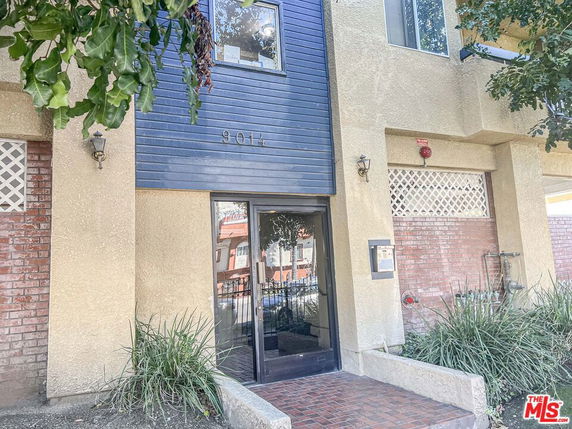 Front view of a building entrance with brick and stucco facade.