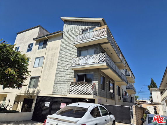 Front view of a multi-story apartment building with balconies.