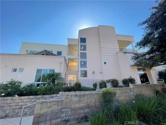 Front view of a modern multi-story building with large windows and balconies.