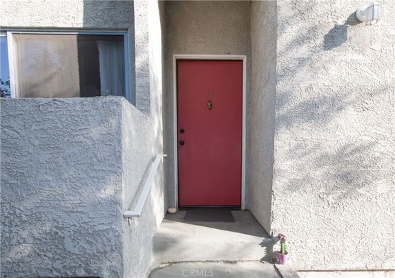 Front view of a building entrance with a red door.