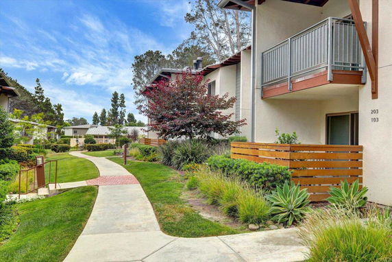 Exterior view of a residential area with a pathway and landscaped garden.