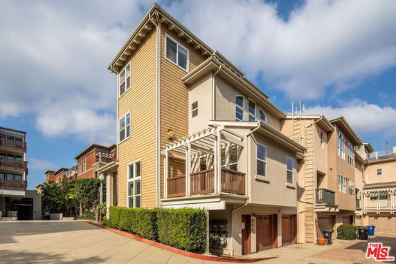 Front view of a multi-story house with a balcony and garage.
