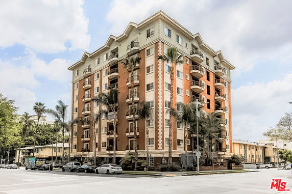 Front view of a multi-story residential building with balconies.