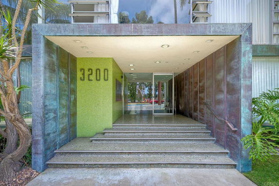 Front view of a building entrance with steps and glass doors.