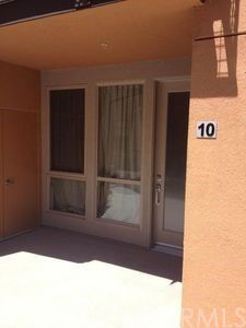 Front view of a building entrance with large windows and door marked number 10.