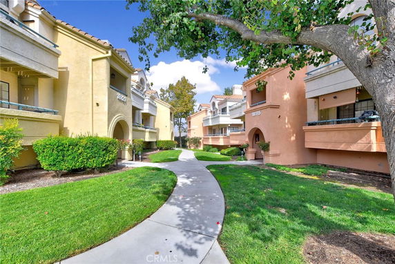 Front view of a two-story residential building with arched entryways and balconies.