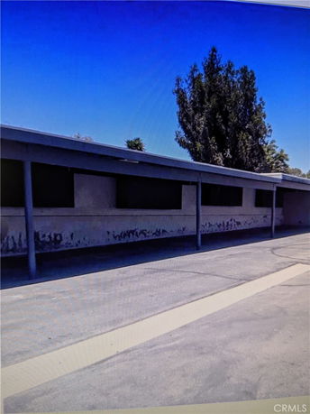 Front view of a long, single-story building with a flat roof and row of windows.