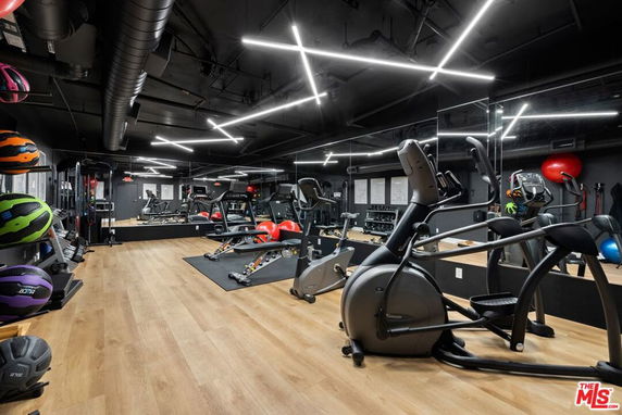 Interior view of a gym with exercise equipment and mirrored walls.