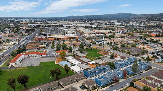 Wide-angle aerial view of an urban area with residential and commercial buildings.