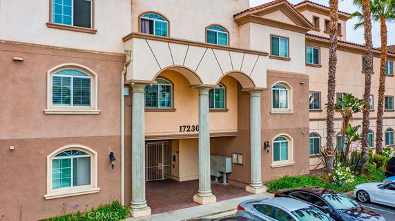 Front view of a multi-story building with an arched entrance and columns.