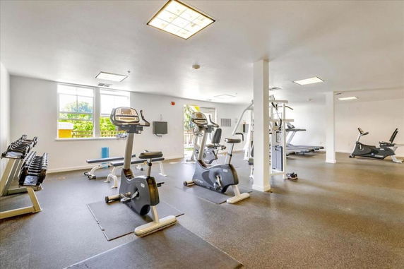 Interior view of a gym area with exercise equipment including stationary bikes and treadmills.