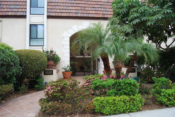 Front view of a house with a tiled roof and an arched entrance.