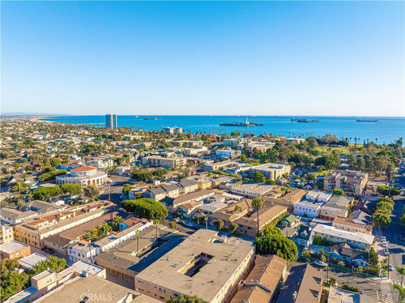 Wide-angle view of a coastal city with buildings and ocean in the background.