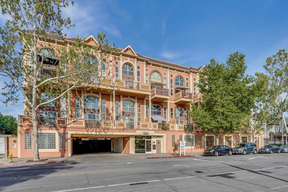 Front view of a three-story building with arched windows and balconies.