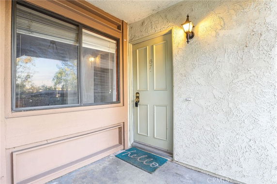Front entrance of a building with a wooden door and window.