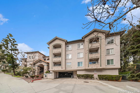 Front view of a multi-story apartment building with balconies.
