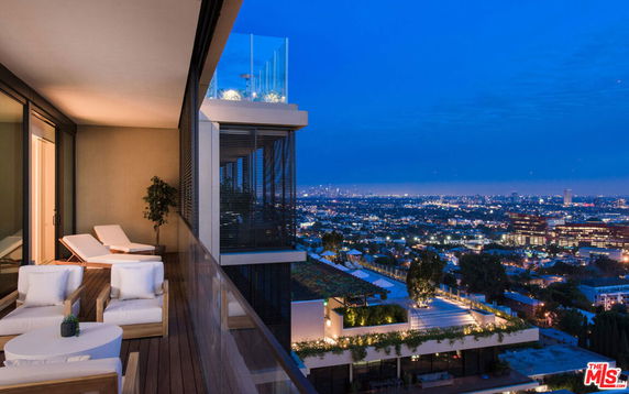 Nighttime view from a high balcony overlooking a cityscape.