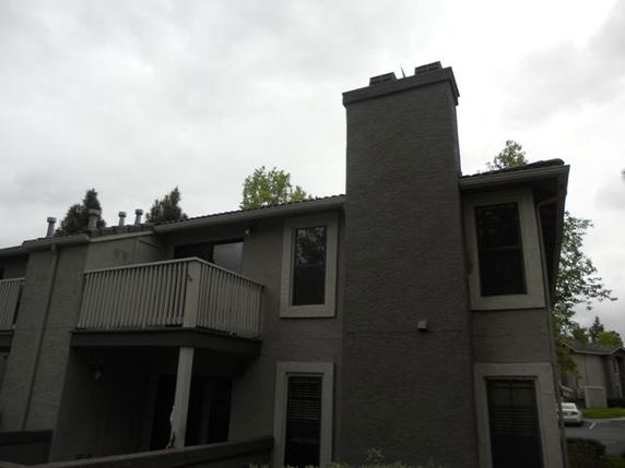 Front view of a two-story residential building with a balcony and chimney.